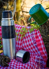 A flask, a picnic rug and a mug. A flask, a picnic rug and a mug.