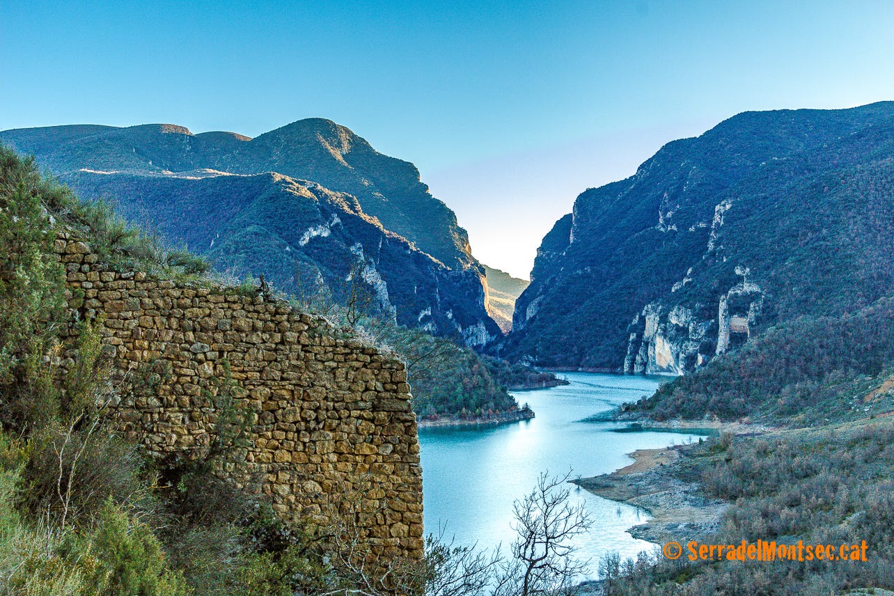 Restes de murs de l'antiga població medieval de Girbeta la Vella. Al fons, el Congost de Mont-rebei amb la silueta de la "cara de dona" ben marcada. Girbeta. Viacamp i Lliterà, Ribagorça. Osca, Aragó. Montsec de l'Estall.