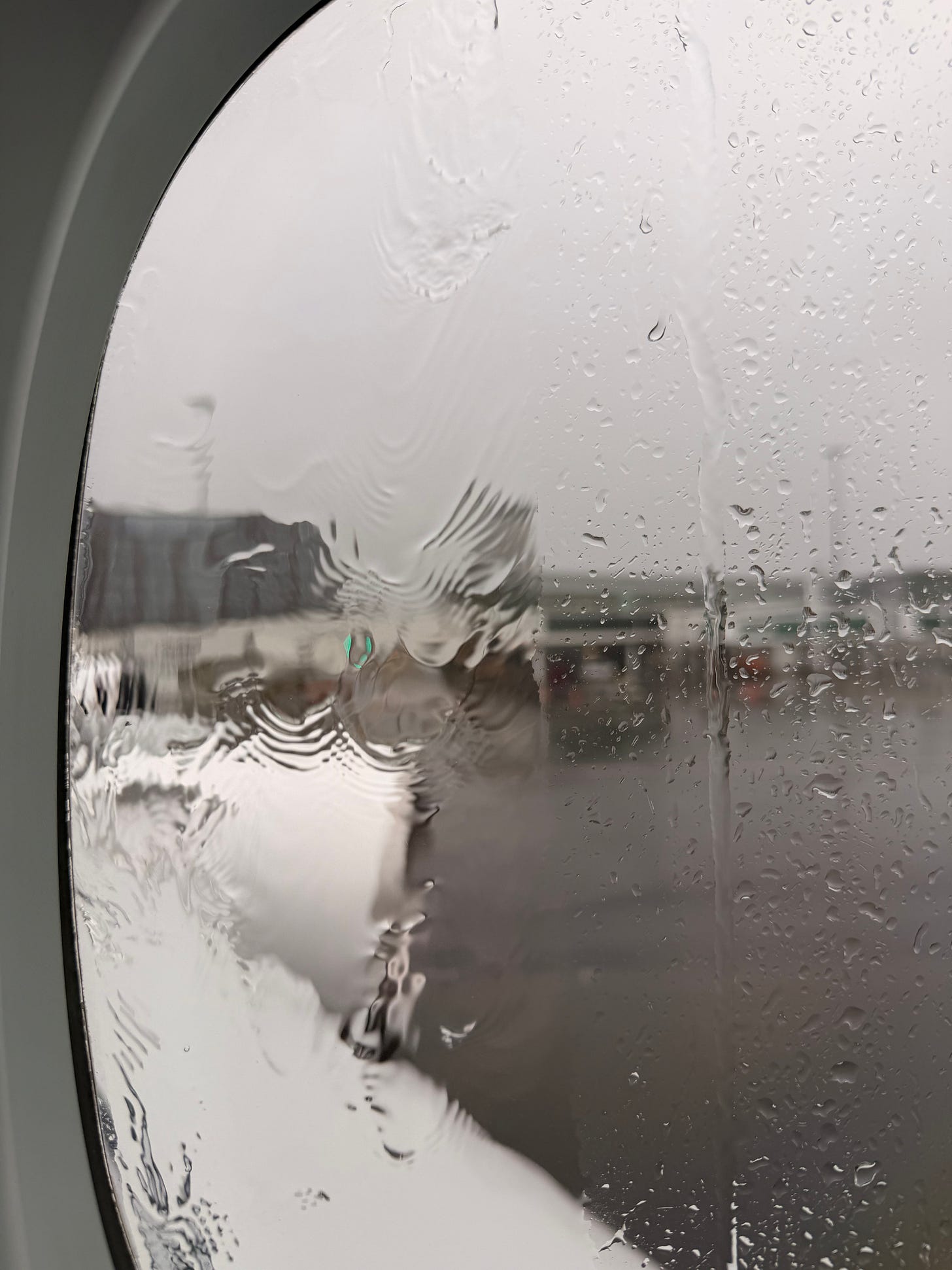 Rain streaking across airplane window as plane departs New Zealand. Rain streaking across airplane window as plane departs New Zealand.