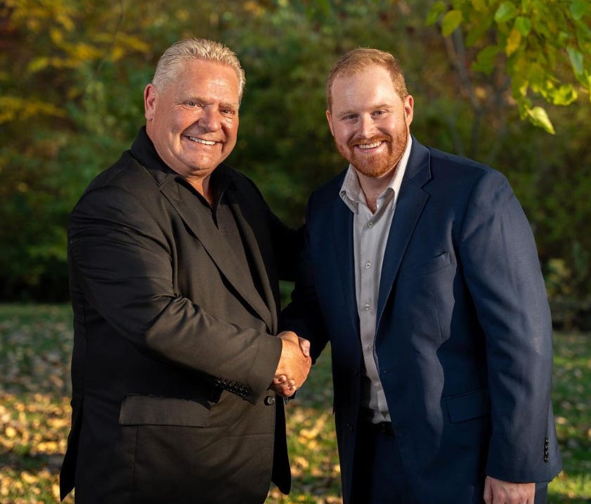 Premier Ford on left shaking Rob Elliott's hand, who is on the right