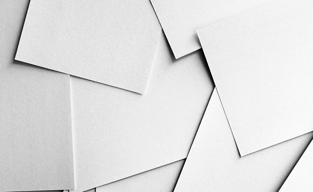 Scattered sheets of white paper covering the entire frame