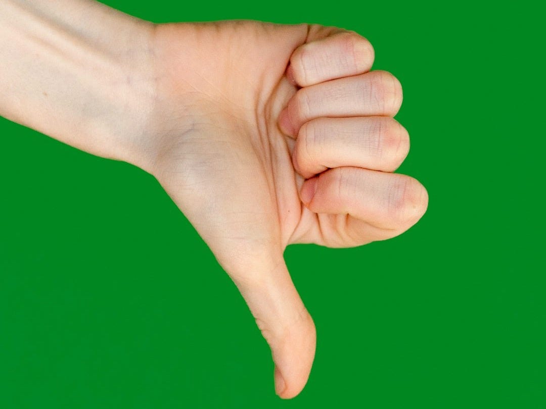 a person's hand holding a cell phone in front of a green background a person's hand holding a cell phone in front of a green background