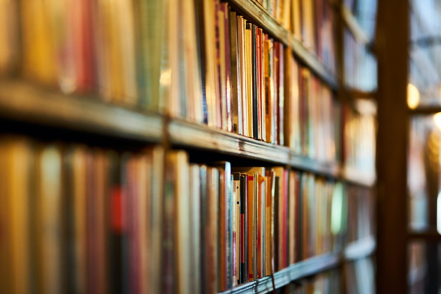 Three bookshelves, stuffed with books. The photo is taken at an angle, so the bookshelves appear to go on forever