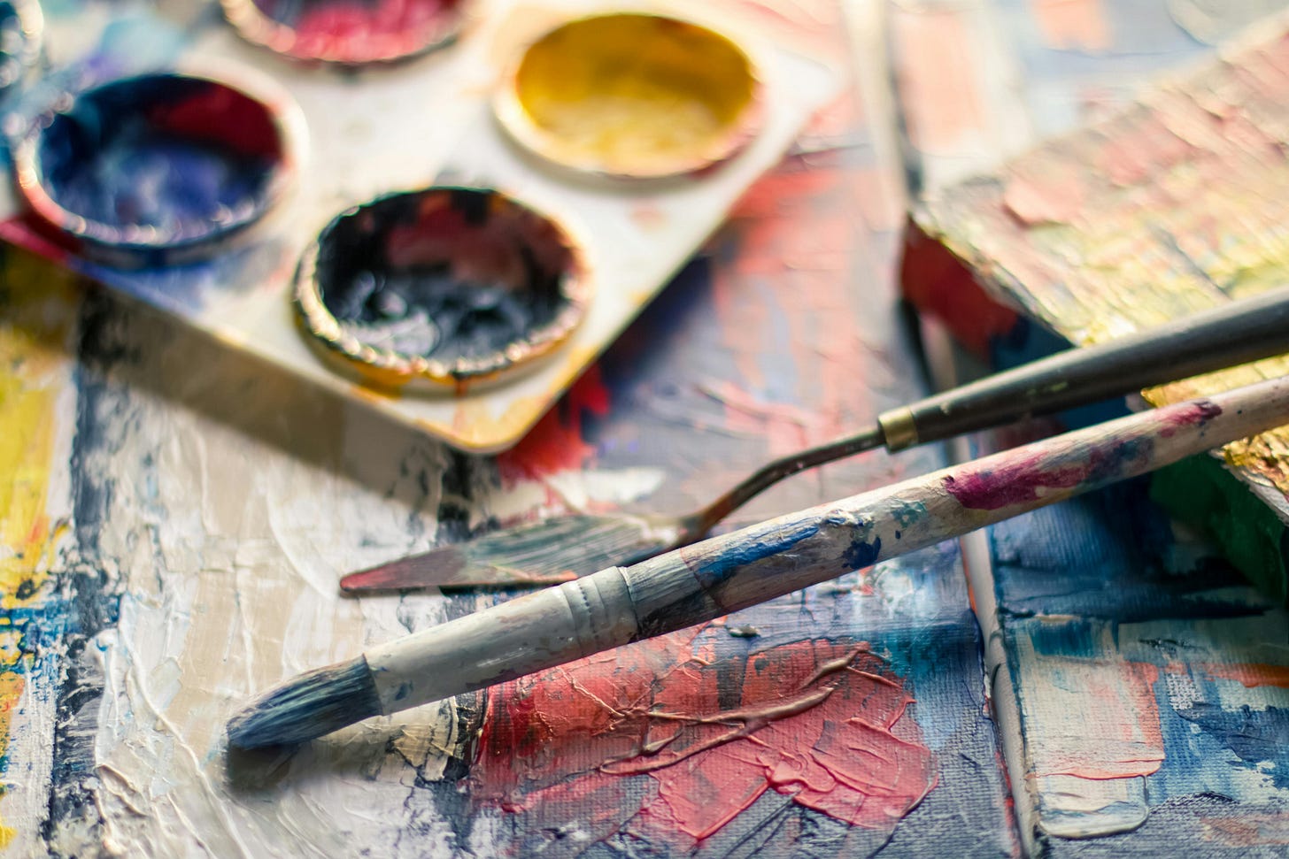 Close up photo of a painter's art palette, paintbrushes, and other art supplies. Close up photo of a painter's art palette, paintbrushes, and other art supplies.
