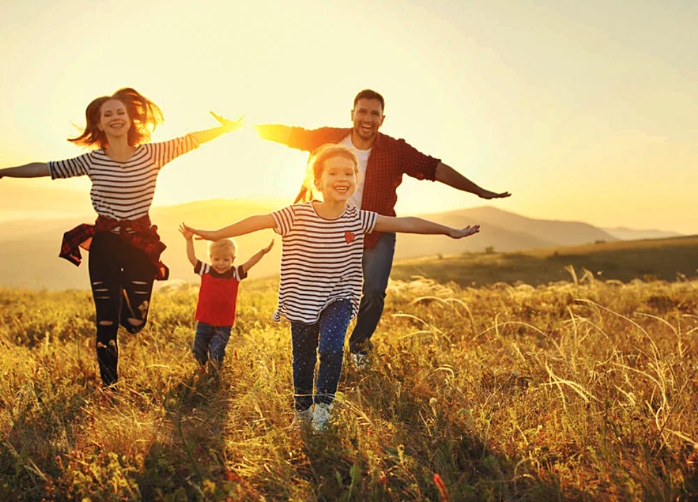 Couple et jeunes enfants courant dans un champ