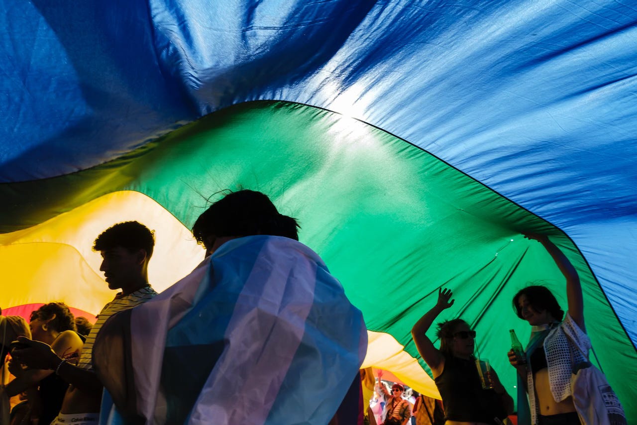 Marchers are seen under a giant rainbow flag during the Pride parade in Lisbon.