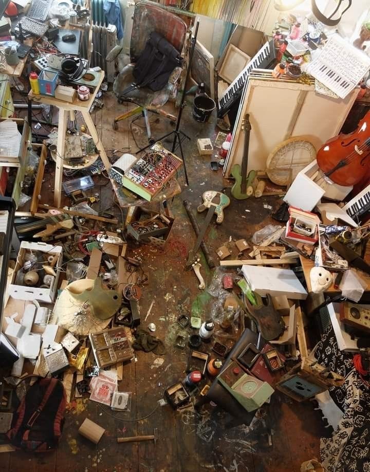 This may contain: a room filled with lots of clutter and junk next to a wall mounted guitar This may contain: a room filled with lots of clutter and junk next to a wall mounted guitar