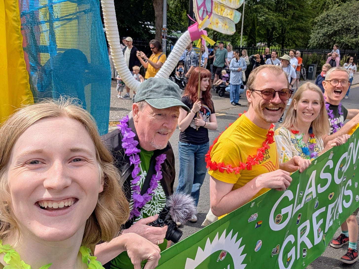 Selfie of Ellie marching with the Glasgow Greens banner and a number of local party members, including Cllr Jon Molyneux.