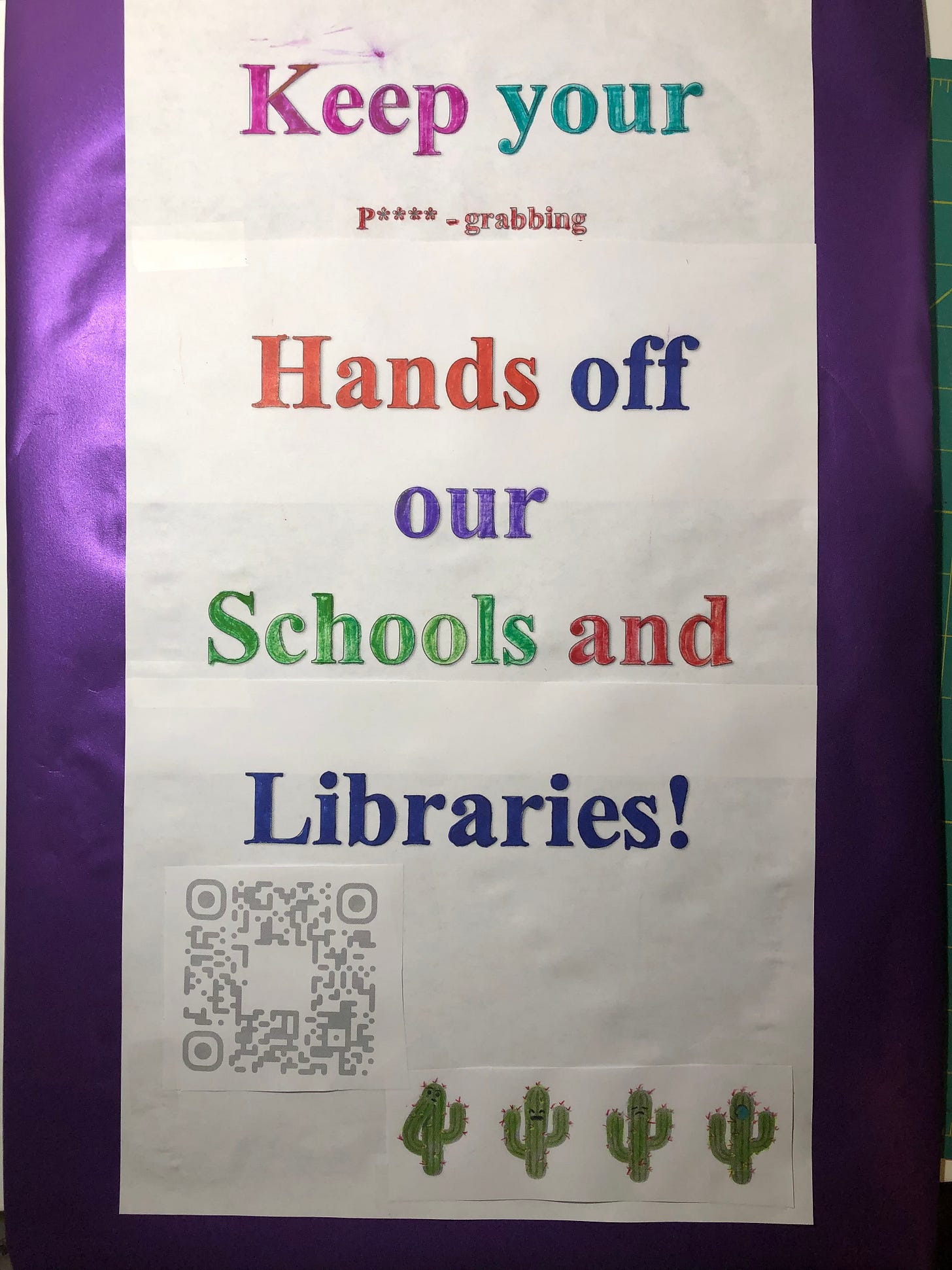 Poster with purple background behind white paper that says “Keep your p****-grabbing hands off our schools and libraries!”