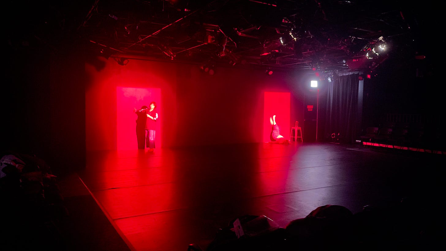 Erin and Kara bathed in pink light, performing in KNOCKOUT