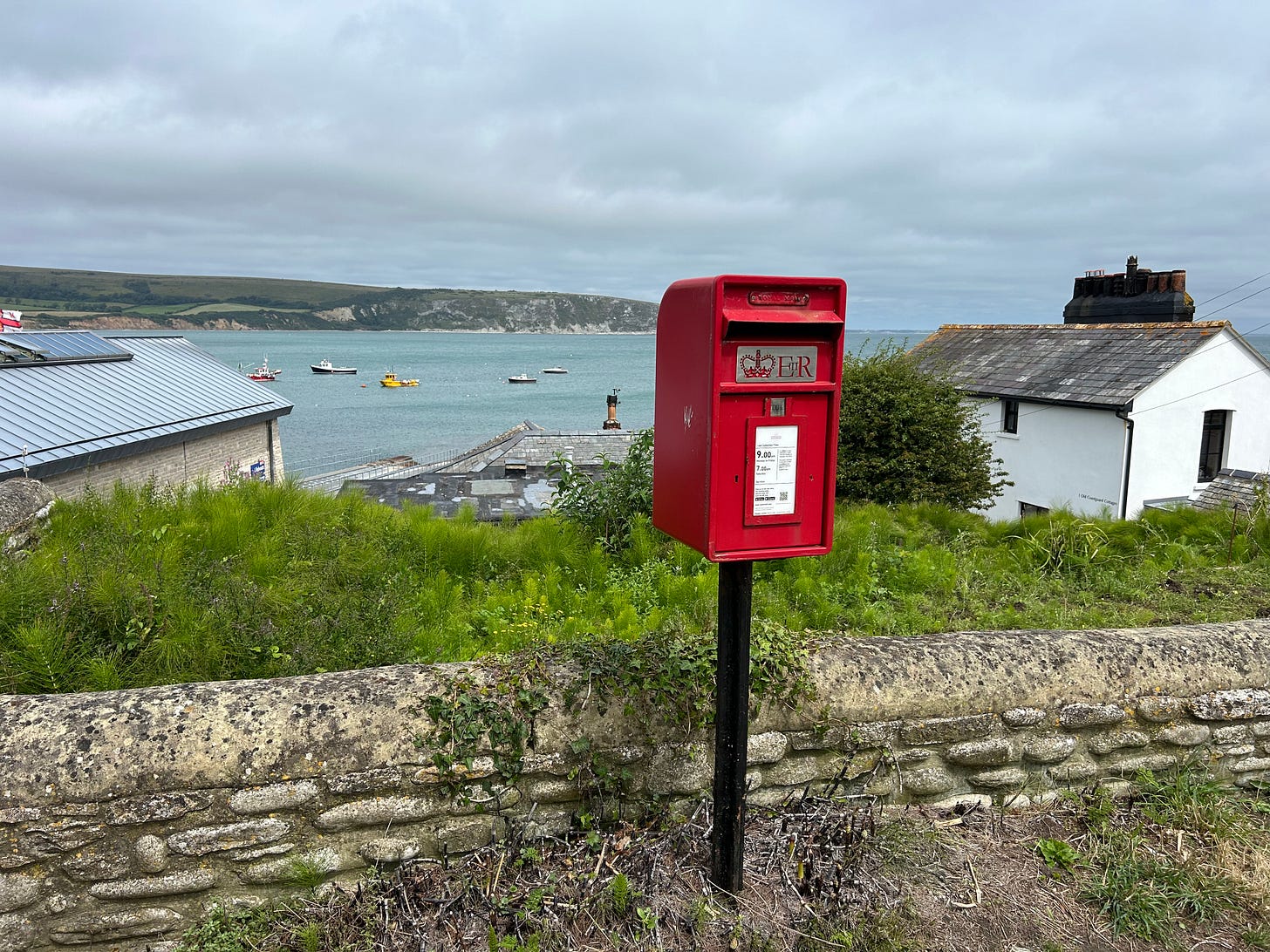 A red mail box with views across the bay in Swanage, Dorset.