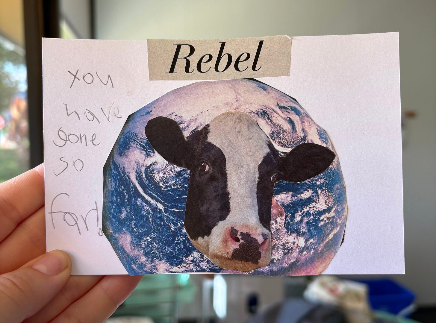 Cow head on top of the planet Earth with text around it.