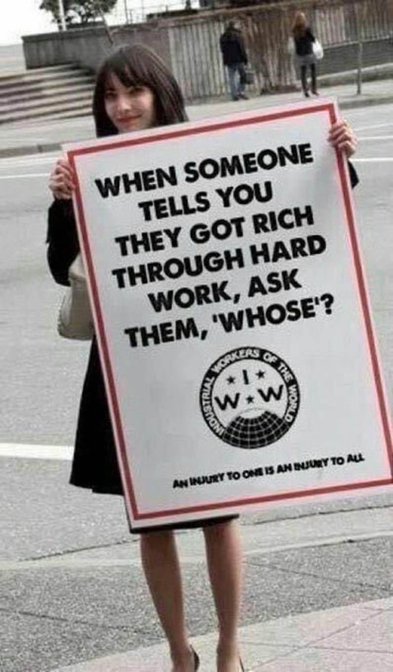 Eine historische Buch- oder Straßenszene, in der eine Frau ein großes weißes Plakat mit rotem Rand hochhält. Auf dem Schild steht in fetten, schwarzen Großbuchstaben der englische Slogan: „WHEN SOMEONE TELLS YOU THEY GOT RICH THROUGH HARD WORK, ASK THEM, 'WHOSE'?“. In der Mitte ist das kreisrunde Logo der Arbeiterorganisation „Industrial Workers of the World“ (IWW) zu sehen, am unteren Rand steht der Text: „AN INJURY TO ONE IS AN INJURY TO ALL“. Eine historische Buch- oder Straßenszene, in der eine Frau ein großes weißes Plakat mit rotem Rand hochhält. Auf dem Schild steht in fetten, schwarzen Großbuchstaben der englische Slogan: „WHEN SOMEONE TELLS YOU THEY GOT RICH THROUGH HARD WORK, ASK THEM, 'WHOSE'?“. In der Mitte ist das kreisrunde Logo der Arbeiterorganisation „Industrial Workers of the World“ (IWW) zu sehen, am unteren Rand steht der Text: „AN INJURY TO ONE IS AN INJURY TO ALL“.