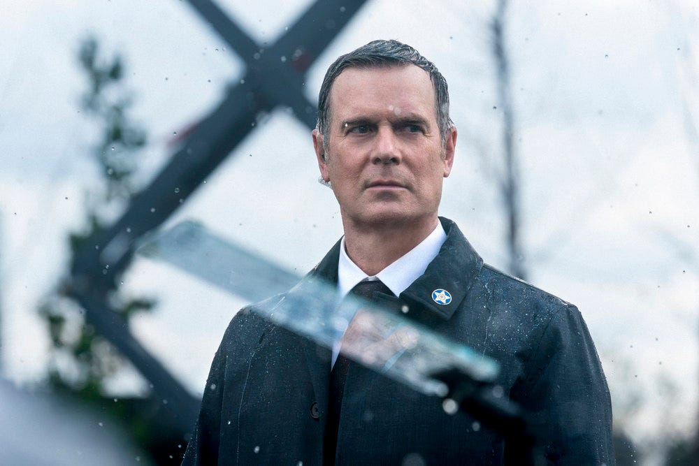 Peter Krause as Mike Hollingsworth in Line of Fire Episode 5 "Cul de Sac" in a flashback of a presidential protection detail in the rain Peter Krause as Mike Hollingsworth in Line of Fire Episode 5 "Cul de Sac" in a flashback of a presidential protection detail in the rain