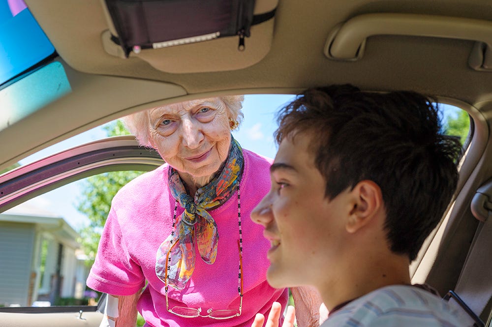 An old person and a young person in a car

Description automatically generated