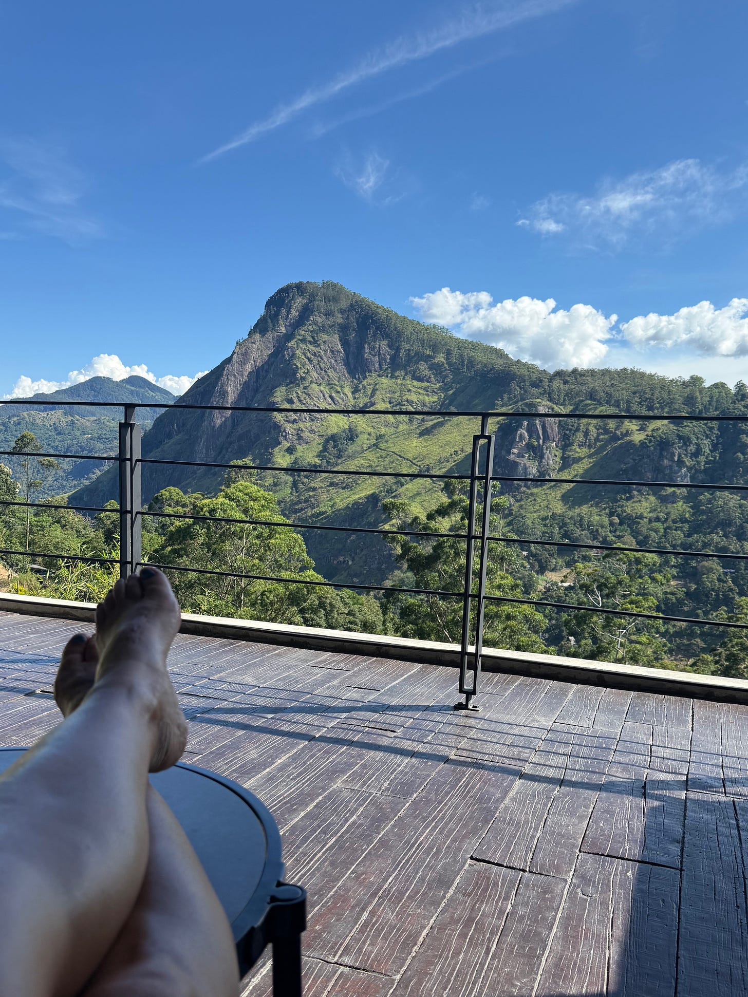 sitting on a balcony with a view of a mountain sitting on a balcony with a view of a mountain