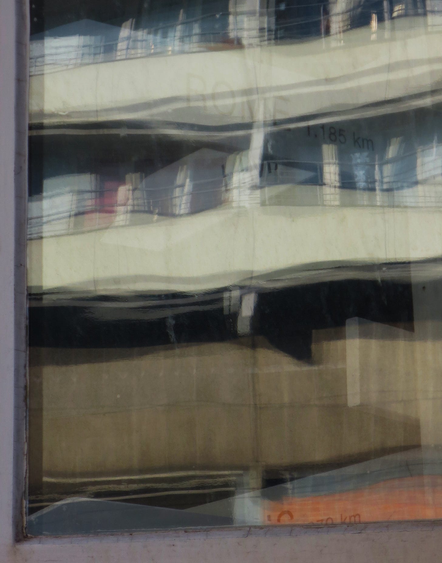 Fotografia del riflesso di una finestra, dove spiccano elementi architettonici di un palazzo moderno Fotografia del riflesso di una finestra, dove spiccano elementi architettonici di un palazzo moderno