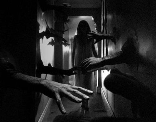 A black and white still from the movie Repulsion, showing a young woman walking down a hallway, with hands coming out of the walls.