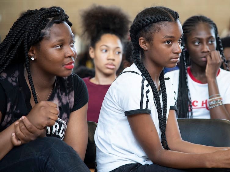 Four Black youth listen attentively Four Black youth listen attentively