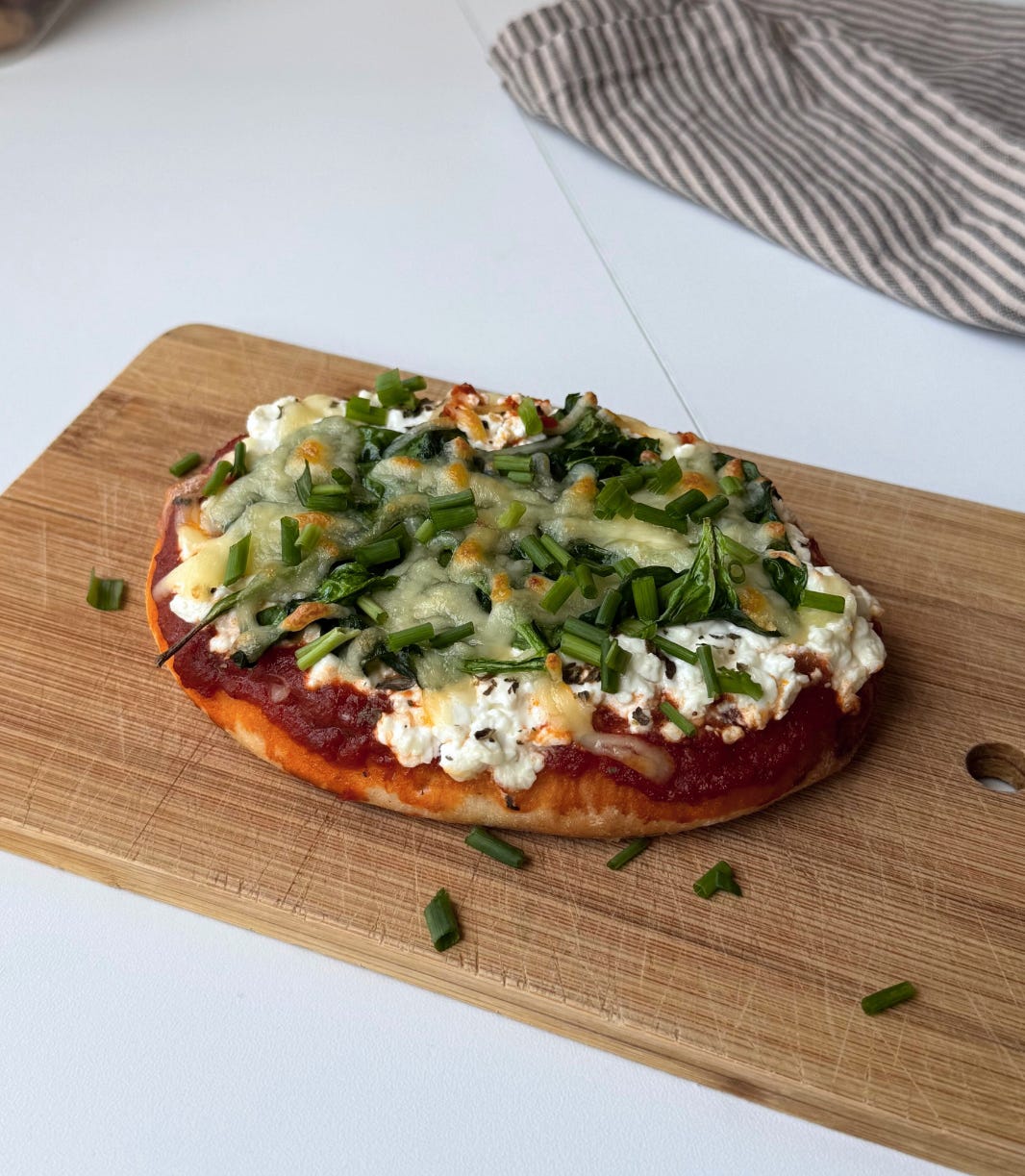 Side view of a personal flatbread pizza with crispy edges, melty cheese, and fresh herbs, ready to eat for a quick snack or meal. Side view of a personal flatbread pizza with crispy edges, melty cheese, and fresh herbs, ready to eat for a quick snack or meal.