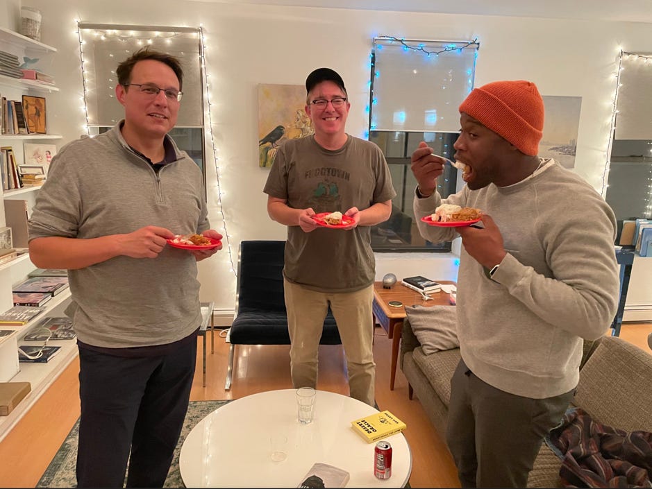 Steve Kornacki holds a plate of food, Kmele Foster is eating pie, in the middle Matt Welch is smiling 