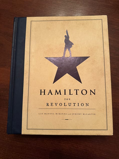 A photo of the cover of the book Hamilton: The Revolution, plus a sampling of pages from Hamilton: The Revolution