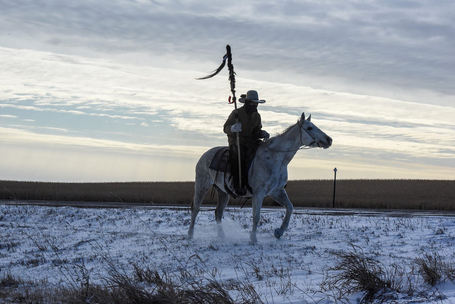 A Lakota person rides a horse during to meet the descendant of the commander of the Wounded Knee massacre on the Cheyenne River reservation in November, 2019 [Stephanie Keith/Reuters]