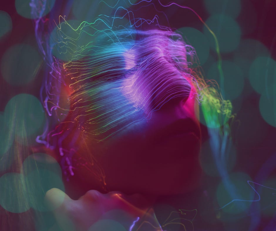 Abstract portrait of a face bathed in neon light trails, eyes closed in trance-like stillness.