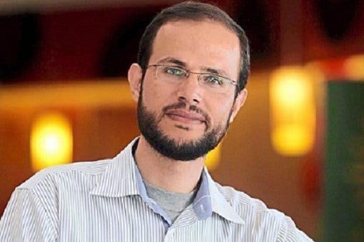 A person with a beard and glasses

Description automatically generated