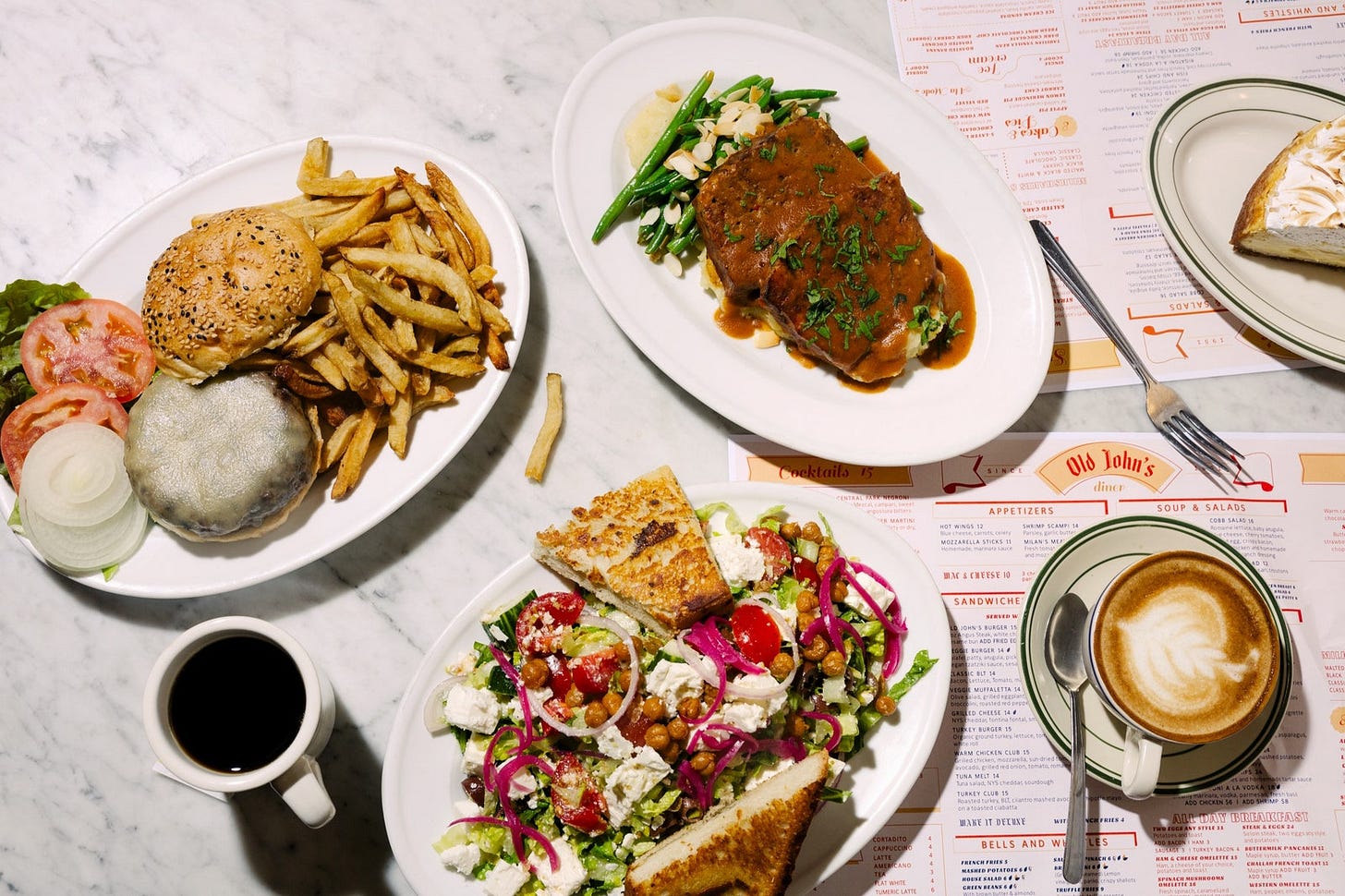 A table of dishes at Old John's set atop the diner's menus. A table of dishes at Old John's set atop the diner's menus.