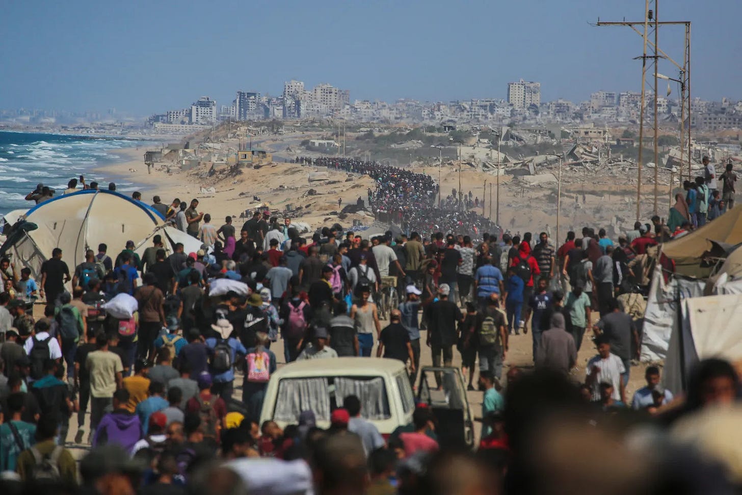 Palestinians walk along al-Rashid road toward Gaza City.