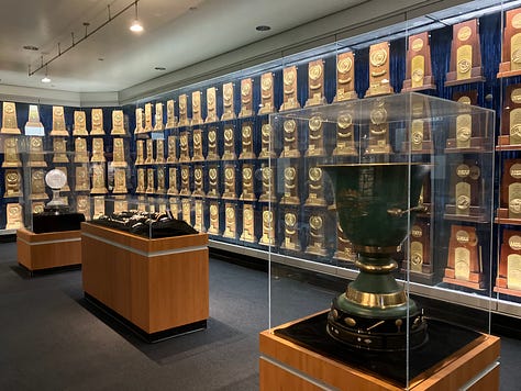 Images of John Wooden, his den, trophies, and author standing by the John Wooden monument