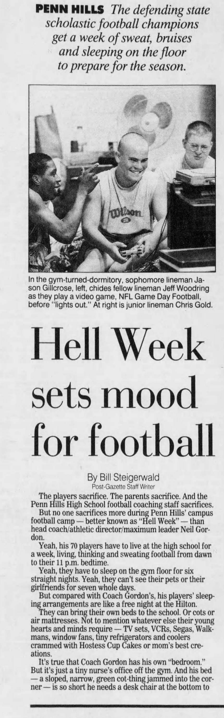 PAGE 8 S A TE THE REGION PENN HILLS The defending state scholastic football champions get a week of sweat, bruises and sleeping on the floor to prepare for the season. In the gym-turned-dormitory, sophomore lineman Jason Gillcrose, left, chides fellow lineman Jeff Woodring as they play a video game, NFL Game Day Football, before "lights out." At right is junior lineman Chris Gold. Hell Week sets mood for football By Bill Steigerwald Post-Gazette Staff Writer The players sacrifice. The parents sacrifice. And the Penn Hills High School football coaching staff sacrifices. But no one sacrifices more during Penn Hills' campus football camp - better known as "Hell Week" - than head coach/athletic director/maximum leader Neil Gordon. Yeah, his 70 players have to live at the high school for a week, living, thinking and sweating football from dawn to their 11 p.m. bedtime. Yeah, they have to sleep on the gym floor for six straight nights. Yeah, they can't see their pets or their girlfriends for seven whole days. But compared with Coach Gordon's, his players' sleeping arrangements are like a free night at the Hilton. They can bring their own beds to the school. Or cots or air mattresses. Not to mention whatever else their young hearts and minds require - TV sets, VCRs, Segas, Walkmans, window fans, tiny refrigerators and coolers crammed with Hostess Cup Cakes or mom's best creations. It's true that Coach Gordon has his own "bedroom." But it's just a tiny nurse's office off the gym. And his bed - a sloped, narrow, green cot-thing jammed into the corner - is so short he needs a desk chair at the bottom to Bob Donaldson/Post-Gazette photos Senior lineman Scott Karavlan scours his portable refrigerator for a beverage after breakfast Friday. He makes the most of his weeklong stay in the gym, bringing a mattress and box spring, refrigerator, fan, lawn chair, portable TV with remote control, reading lamp, stereo radio-alarm clock and cellular phone. And then there're the "Where's Waldo" bedsheets. keep his feet from dangling in midair. But don't you dare cry for Coach Gordon or his coaches, all of whom also share the personal miseries, inconveniences and locker-room smells Hell Week, a 25-year Penn Hills tradition being run by Gordon for the 10th straight year. SEE CAMP, PAGE C-6 DON'T STOP