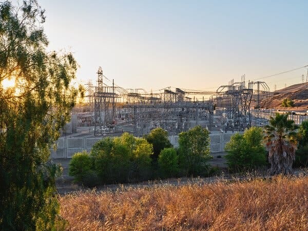 An electrical facility surrounded by dry scrub, trees and low hills. An electrical facility surrounded by dry scrub, trees and low hills.