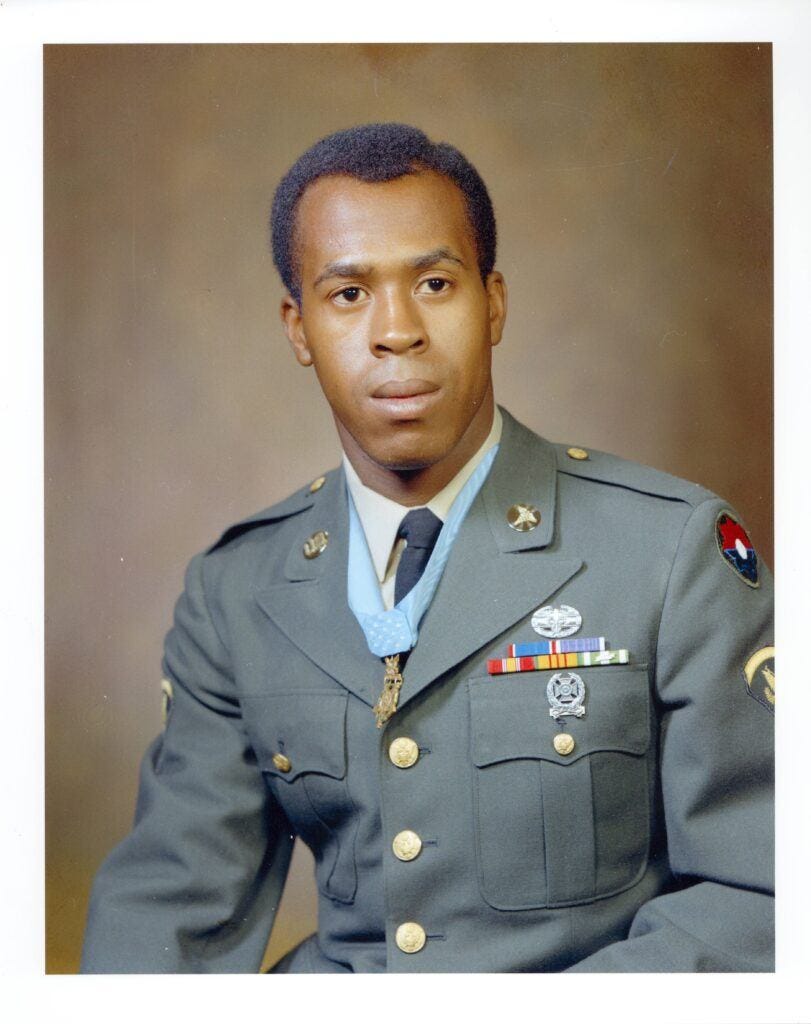 a colorized portrait of Clarence Sasser in dress uniform with the Congressional Medal of Honor around his neck