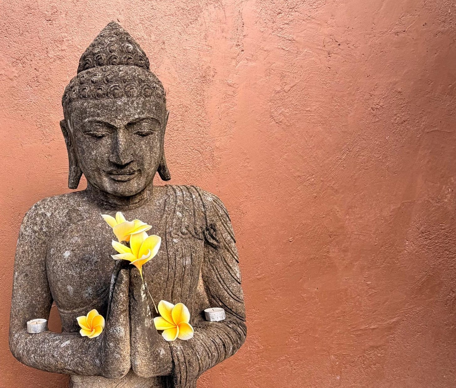 Morning offering with flowers and incense at a Bali villa shrine.