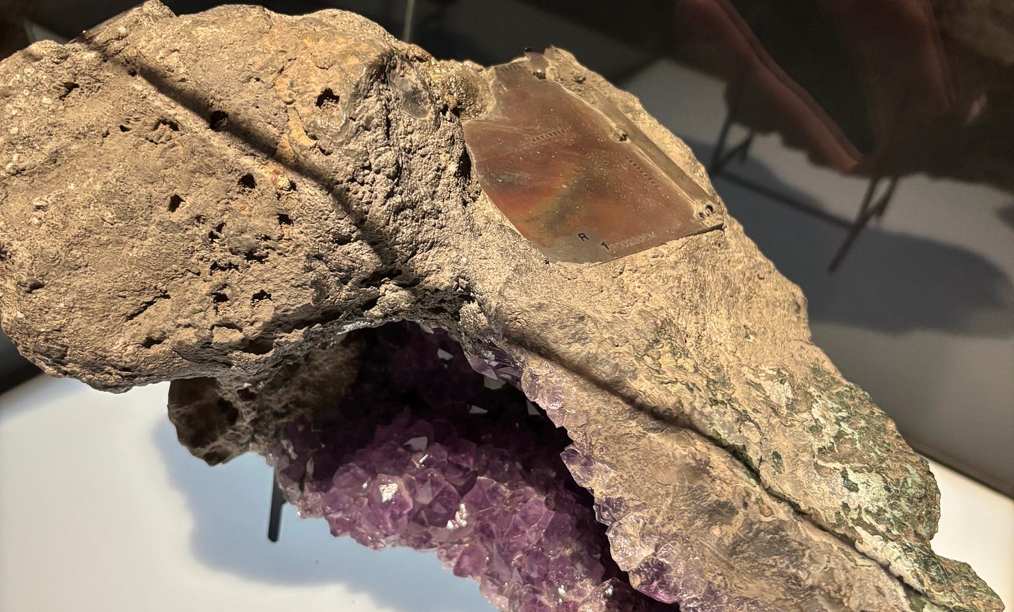 A geode-like rock with a piece of metal embedded within it