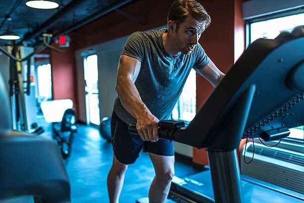 exhausted mid adult man on gym treadmill - treadmill stock pictures, royalty-free photos & images