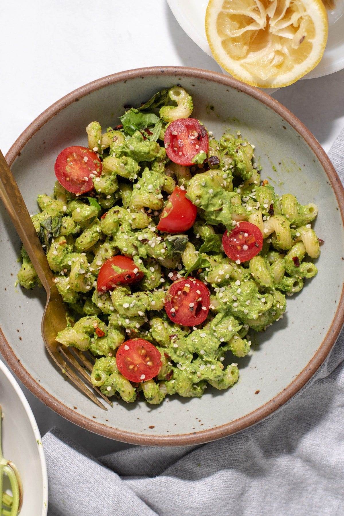 Overhead view of gray bowl filled with green pasta and cherry tomatoes Overhead view of gray bowl filled with green pasta and cherry tomatoes