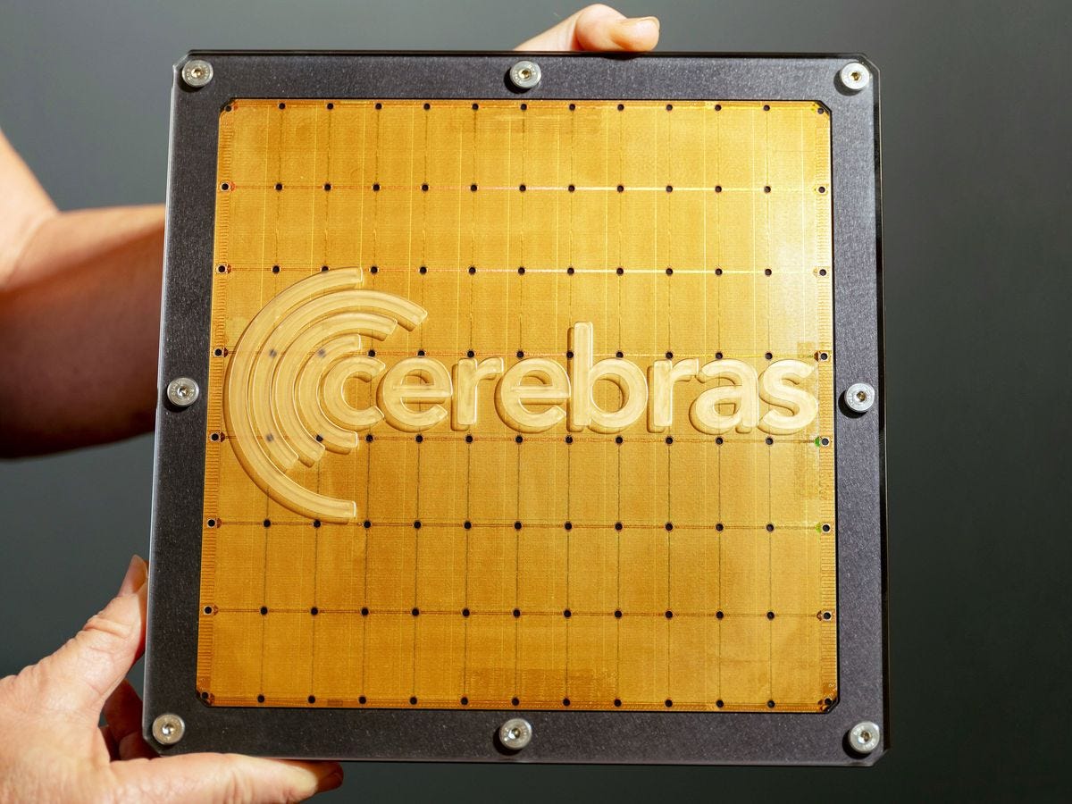 person's hands holding a gold square with a black outline and screws with text in the middle 