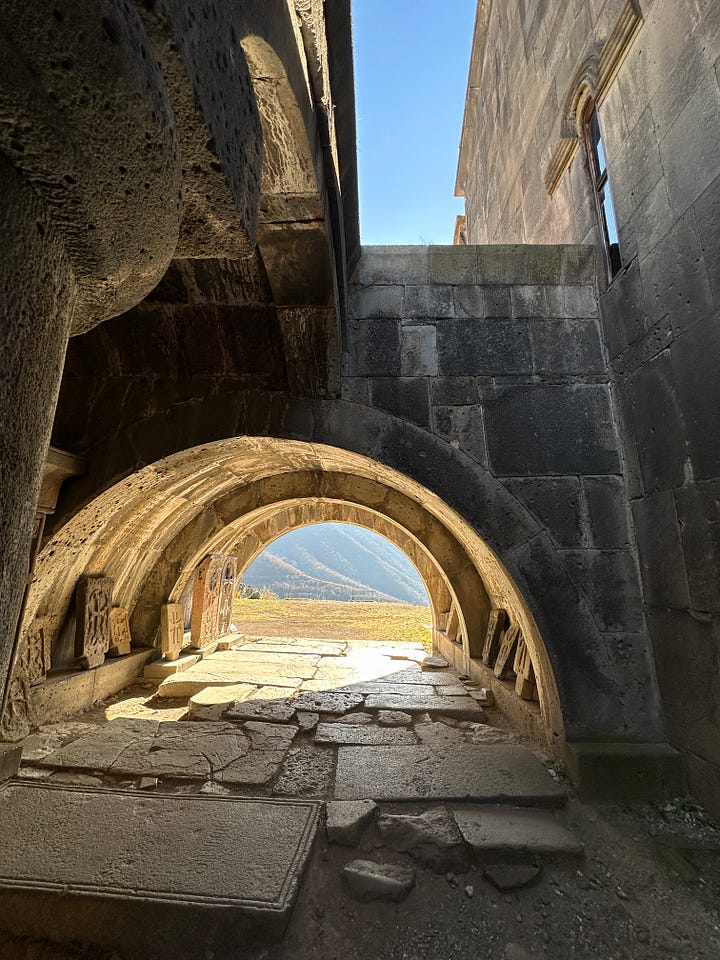 Picture of a landscape view beyond an arch, and a table spread with food