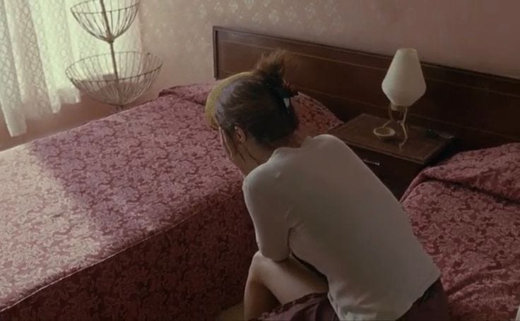 This may contain: a woman sitting on top of a bed in a bedroom
