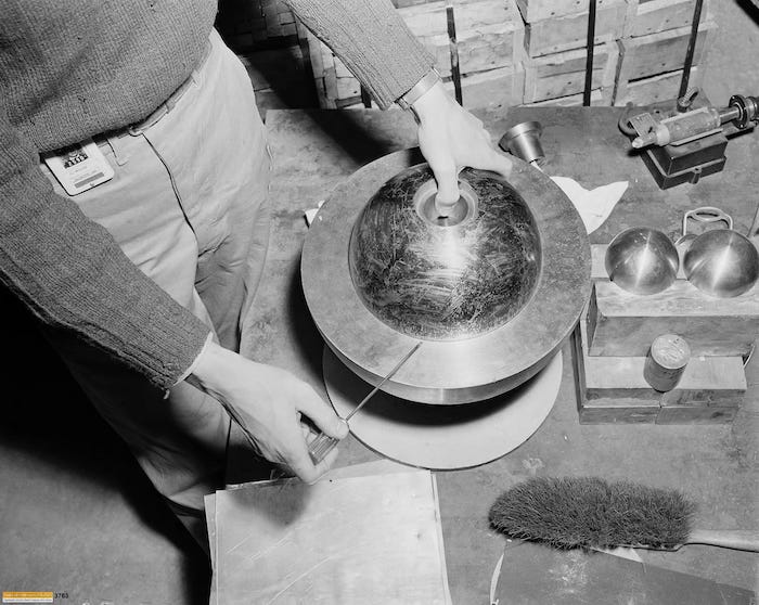 black and white photo of the manual use of a screwdriver on the beryllium tamper over an tomic bomb core black and white photo of the manual use of a screwdriver on the beryllium tamper over an tomic bomb core