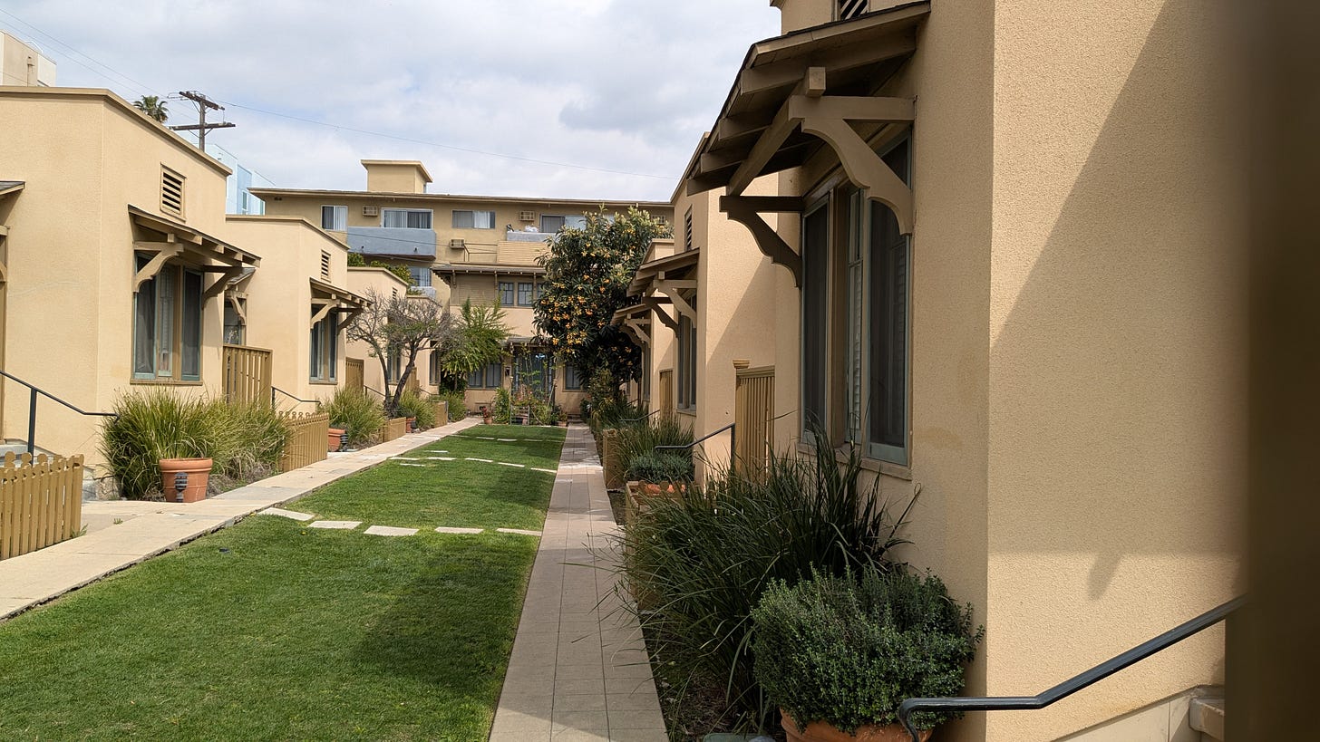 Cream colored bungalows separated by a neatly mown grass lawn Cream colored bungalows separated by a neatly mown grass lawn