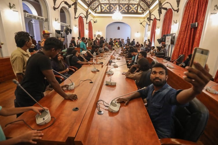 People in a conference room in the Sri Lankan president's palace a day after the storming official residences on July 9 2022. People in a conference room in the Sri Lankan president's palace a day after the storming official residences on July 9 2022.