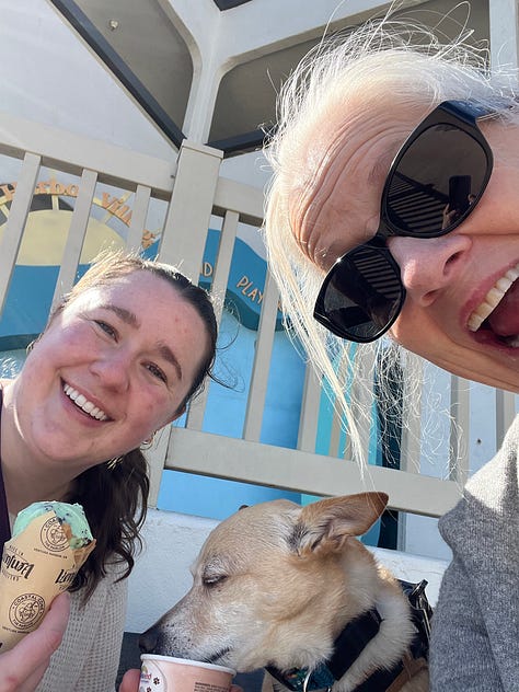 Ventura harbor with boat masts. Red boat. Blue boat. Rose, Natalie and Max eating ice cream. Free mermaid advice: Keep calm and wear pearls. Two dogs sitting together on a rug. A stack of books. Sunset through the trees.