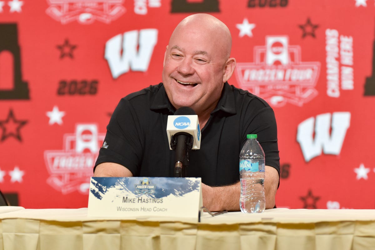 Mike Hastings laughing. Black shirt at press conference. 