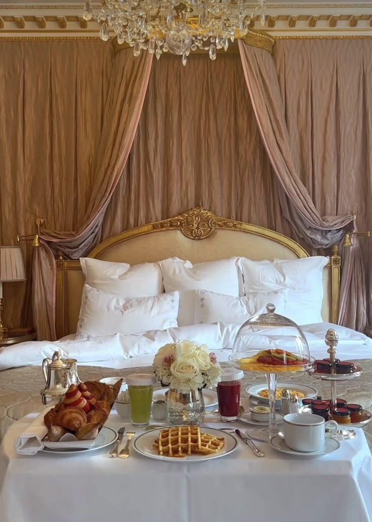 This may contain: a bed room with a neatly made bed and trays of food