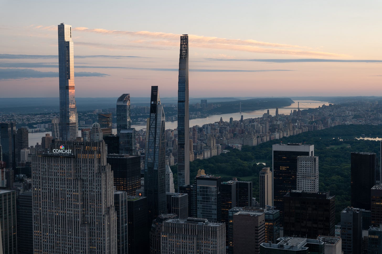 Central Park in dawn light seen from above, the thin towers of Billionaires' Row rising in front of it, pastel cloud across the sky and the Hudson at the left. Central Park in dawn light seen from above, the thin towers of Billionaires' Row rising in front of it, pastel cloud across the sky and the Hudson at the left.