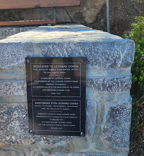 Collage of three images from Hydra, Greece: a plaque mounted on stone dedicating a park bench to Leonard Cohen, a close-up of the plaque with bilingual text in English and Greek, and a pale green front door believed to be Cohen’s home, framed by whitewashed walls and a tree.